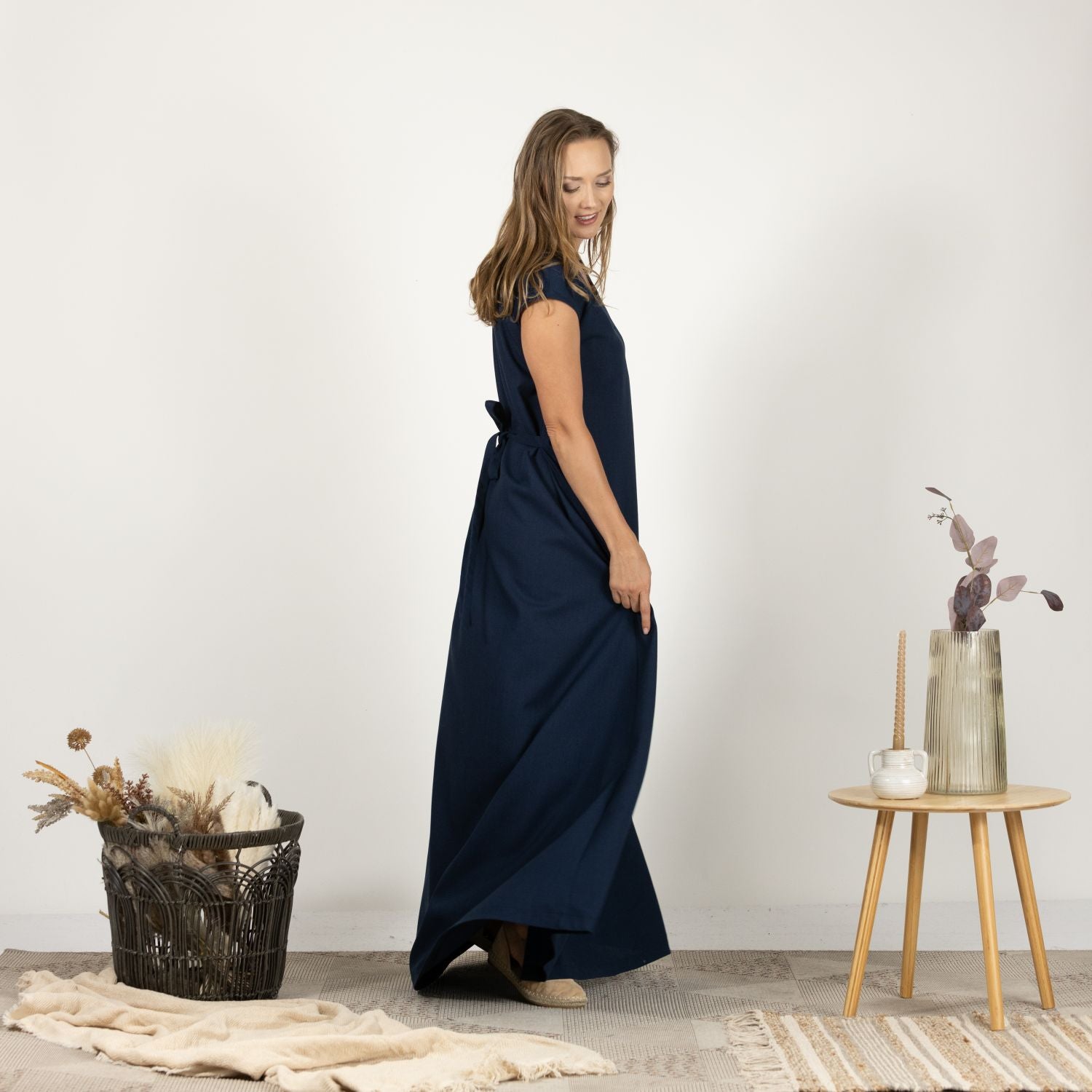 Side view of the model wearing the Linen Loose Dress with Back Tie, illustrating the relaxed fit and graceful flow.